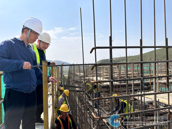 侯爭光(左一)在工程現(xiàn)場檢查混凝土澆筑倉號